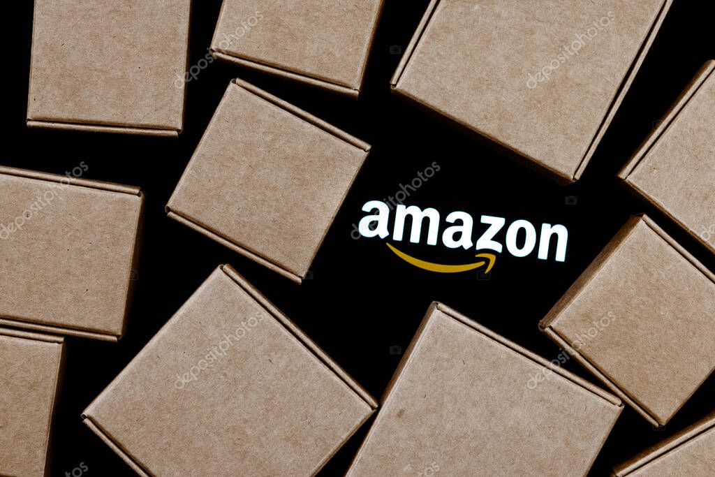 Kazan, Russia - Oct 02, 2021: Amazon is an American company, one of the world's largest e-commerce platform markets. Amazon logo on a black background surrounded by parcel boxes.