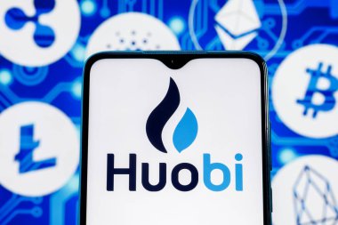 Kazan, Rusya - Ekim 05, 2021: Huobi bir kripto döviz kurudur. Ana kripto para birimlerinin arka planına karşı akıllı telefon ekranında Huobi logosu.