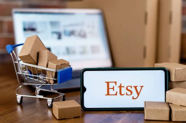 Kazan, Rusya - 6 Ekim 2021: Etsy, ABD 'li bir e-ticaret şirketidir. Ekranda Etsy logosu olan akıllı telefon, alışveriş arabası ve laptop..