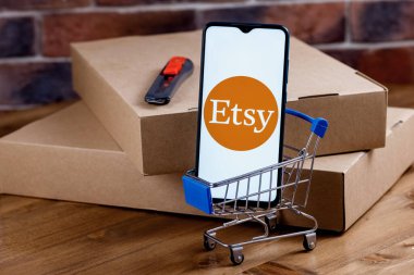 Kazan, Rusya - 6 Ekim 2021: Etsy, ABD 'li bir e-ticaret şirketidir. Ekranda Etsy logosu olan akıllı telefon, alışveriş arabası ve paketler..