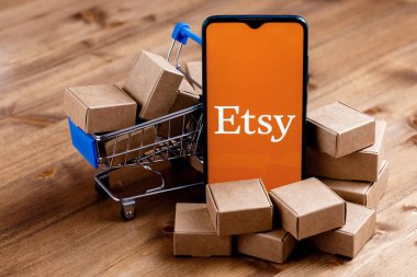 Kazan, Rusya - 6 Ekim 2021: Etsy, ABD 'li bir e-ticaret şirketidir. Ekranda Etsy logosu olan akıllı telefon, alışveriş arabası ve paketler..