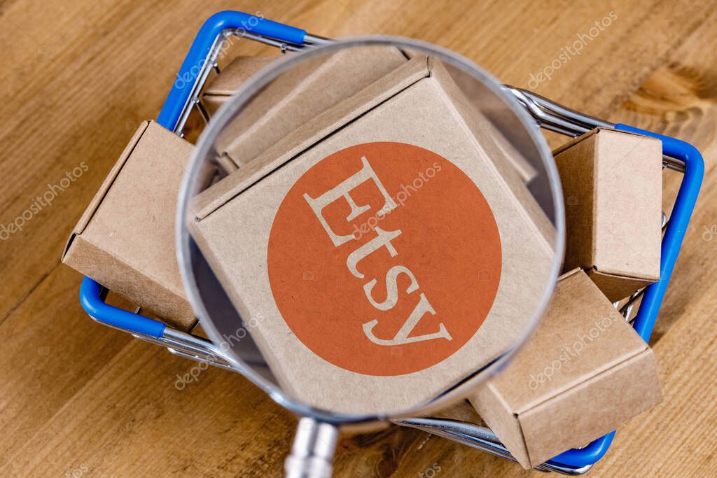 Kazan, Russia - Oct 6, 2021: Etsy is American e-commerce company focused on handmade items and craft supplies. Modified photo of Etsy logo on a box under magnifying glass in the shopping cart.