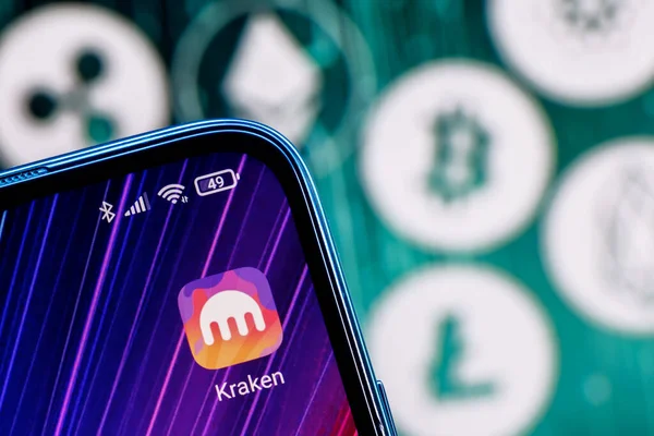 Kazan, Rusya - 12 Ekim 2021 Kraken kripto para değişimi. Akıllı telefon ekranındaki Kraken uygulaması ana kripto para birimlerinin arka planına karşı.