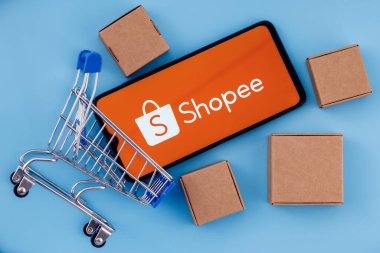 Kazan, Rusya - 14 Ekim 2021 Shopee bir e-ticaret teknoloji şirketidir. Ekranda Shopee logosu olan akıllı telefon, alışveriş arabası ve paketler..