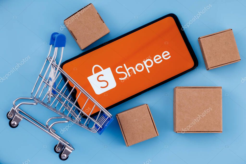 Kazan, Russia - Oct 14, 2021: Shopee is e-commerce technology company. Smartphone with Shopee logo on the screen, shopping cart and parcels.