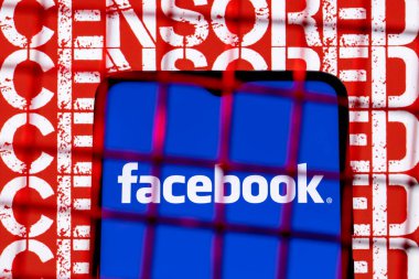 Kazan, Rusya - 19 Ekim 2021: Arkaplandaki parmaklıkların arkasındaki akıllı telefon ekranındaki Facebook sosyal ağ logosu sansürlenmiş. Facebook sansür ve yasaklama kavramı..