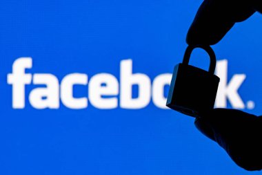 Kazan, Rusya - 19 Ekim 2021: Facebook sosyal ağ logosunun arka planında parmaklar kapalı bir güvenlik kilidi tutuyor. Facebook 'ta veri güvenliği kavramı.
