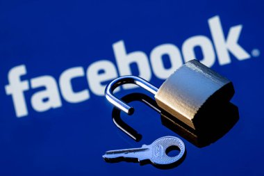 Kazan, Rusya - 19 Ekim 2021: Aynadaki yansımada Facebook sosyal ağ logosunun arka planında açık bir güvenlik kilidi ve anahtarı.