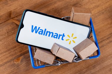 Kazan, Rusya - 20 Ekim 2021: Walmart, ABD 'li çok uluslu perakende şirketi. Ekranında Walmart logosu olan akıllı telefon, alışveriş arabası ve paketler..