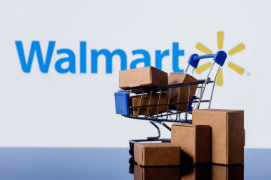 Kazan, Rusya - 20 Ekim 2021: Walmart, ABD 'li çok uluslu perakende şirketi. Walmart logosunun arka planında paketler olan alışveriş arabası..