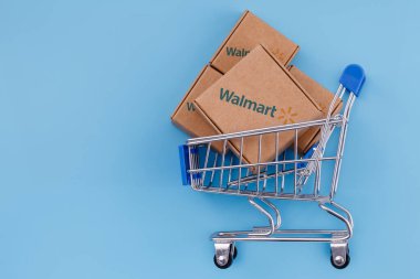 Kazan, Rusya - 20 Ekim 2021: Walmart, ABD 'li çok uluslu perakende şirketi. Modifiye edilmiş Walmart logosu olan paket mavi arka planda..