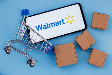Kazan, Rusya - 20 Ekim 2021: Walmart, ABD 'li çok uluslu perakende şirketi. Ekranında Walmart logosu olan akıllı telefon, alışveriş arabası ve paketler..