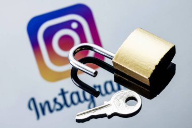 Kazan, Rusya - 21 Ekim 2021: Aynadaki yansımada Instagram sosyal ağ logosunun arka planında açık güvenlik kilidi ve anahtarı.
