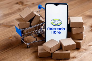 Kazan, Rusya - 22 Ekim 2021: Mercado Libre, Arjantinli çevrimiçi pazarlama şirketi. Ekranda Mercado Libre logosu olan akıllı telefon, alışveriş arabası ve paketler..