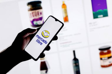 Kazan, Rusya - 22 Ekim 2021: Mercado Libre, Arjantinli çevrimiçi pazarlama şirketi. Web sitesi kataloğunun arka planında Mercado Libre logosu olan bir akıllı telefon..