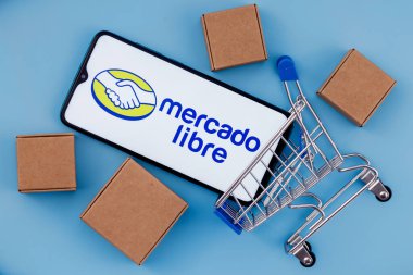 Kazan, Rusya - 22 Ekim 2021: Mercado Libre, Arjantinli çevrimiçi pazarlama şirketi. Ekranda Mercado Libre logosu olan akıllı telefon, alışveriş arabası ve paketler..