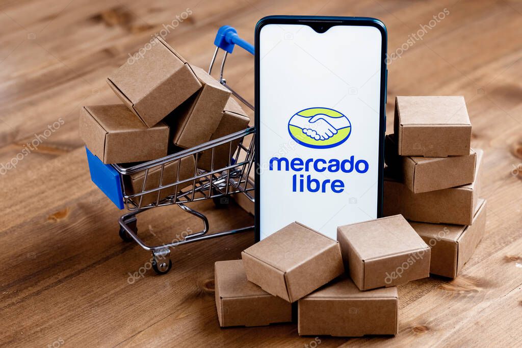 Kazan, Russia - Oct 22, 2021: Mercado Libre is Argentine company that operates online marketplaces. Smartphone with Mercado Libre logo on the screen, shopping cart and parcels.