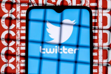 Kazan, Rusya - 23 Ekim 2021: Twitter sosyal ağ logosu arka plandaki parmaklıkların arkasındaki akıllı telefon ekranında sansürlenmiş. Twitter sansür ve yasaklama kavramı.