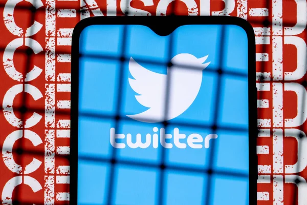 Kazan, Rusya - 23 Ekim 2021: Twitter sosyal ağ logosu arka plandaki parmaklıkların arkasındaki akıllı telefon ekranında sansürlenmiş. Twitter sansür ve yasaklama kavramı.
