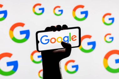 Kazan, Rusya - 26 Ekim 2021: Google teknoloji şirketinin logosuna sahip akıllı telefon arkaplanda sıkışık bir elle ekranda