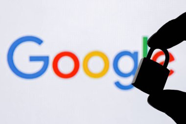Kazan, Rusya - 26 Ekim 2021: Parmaklar Google teknoloji şirketi logosunun arka planında kapalı bir güvenlik kilidi tutuyor. Google 'da veri güvenliği kavramı.