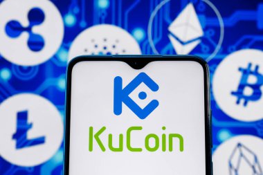 Kazan, Rusya - 26 Ekim 2021: KuCoin şifreli para değişimi. Akıllı telefon ekranındaki KuCoin logosu ana kripto para birimlerinin arka planına karşı.