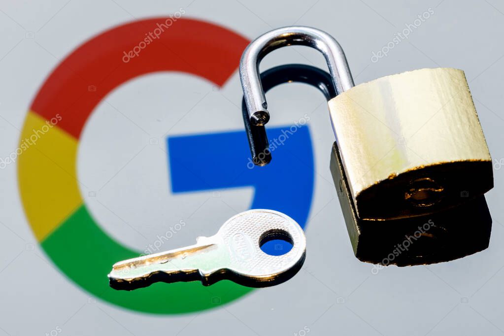 Kazan, Russia - Oct 26, 2021: An open security lock and key on the background of the Google technology company logo in the mirror reflection.