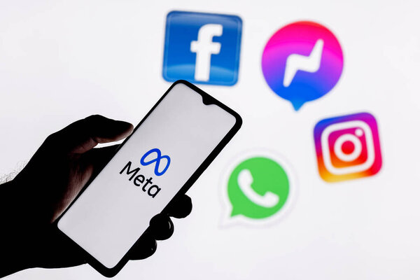 Kazan, Russia - Oct 28, 2021: Facebook changes its name to Meta. Smartphone with Meta logo on the background on logos of products owned by facebook metaverse.