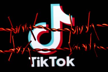 Kazan, Rusya - 31 Ekim 2021: Dikenli tellerin arkasında TikTok sosyal ağ logosu. TikTok sansür ve yasaklama kavramı.