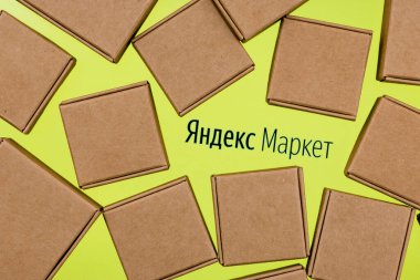 Kazan, Rusya - Kasım 03, 2021: Yandex.Market mal seçip almak için kullanılan bir Rus hizmetidir. Yandex.Market logosu beyaz arka planda. Paket kutularıyla çevrili..