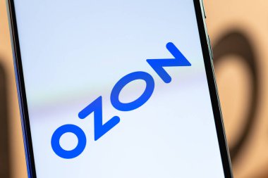 Kazan, Rusya - 28 Aralık 2020: Ozon logosu ekranda yakın plan akıllı telefon. Özon, Rusya 'daki ilk e-ticaret şirketlerinden biri. Paketin arka planında akıllı telefon.