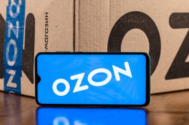 Kazan, Rusya - 28 Aralık 2020: Ozon logosu ekranda yakın plan akıllı telefon. Özon, Rusya 'daki ilk e-ticaret şirketlerinden biri. Paketin arka planında akıllı telefon.