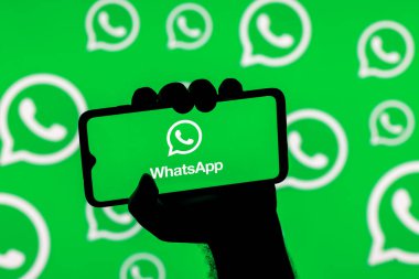 Kazan, Rusya - 08 Kasım 2021: Whatsapp habercisi ile Whatsapp logolarının arka planında sıkışık bir el ile ekranda akıllı telefon