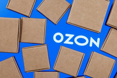 Kazan, Rusya - 10 Kasım 2021: Ozon Rus e-ticaret şirketidir. Paket kutularıyla çevrili beyaz arkaplanda Ozon logosu.