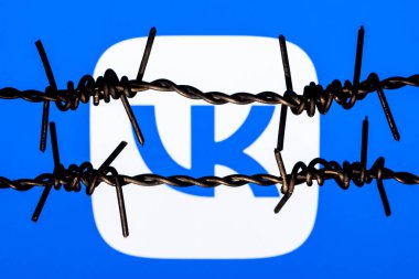 Kazan, Rusya - 13 Kasım 2021: Dikenli tellerin arkasında VKontakte sosyal ağ logosu. VKontakte sansür ve yasaklama kavramı.