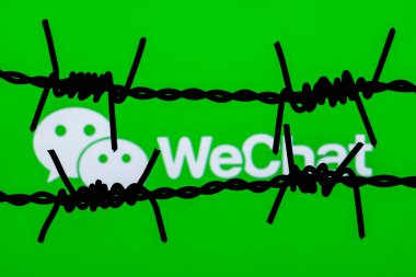 Kazan, Rusya - 16 Kasım 2021: dikenli tellerin arkasında WeChat kurye logosu. WeChat sansür ve yasaklama kavramı.