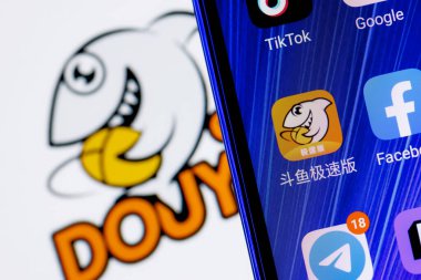 Kazan, Rusya - 21 Kasım 2021: Akıllı telefon ekranındaki diğer uygulamalar arasında DoyUy canlı yayın servis uygulamasının simgesi. Arka planda DoyUy logosu var..