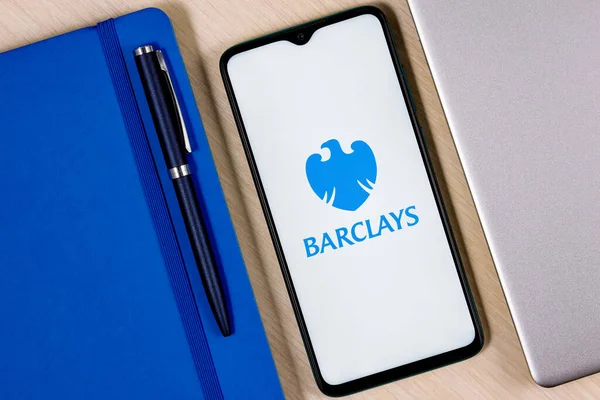 Kazan, Rusya - 03 Aralık 2021: Üzerinde Barclays banka logosu olan akıllı telefon ahşap masa üzerinde dizüstü bilgisayar ve iş planlayıcısının yanında