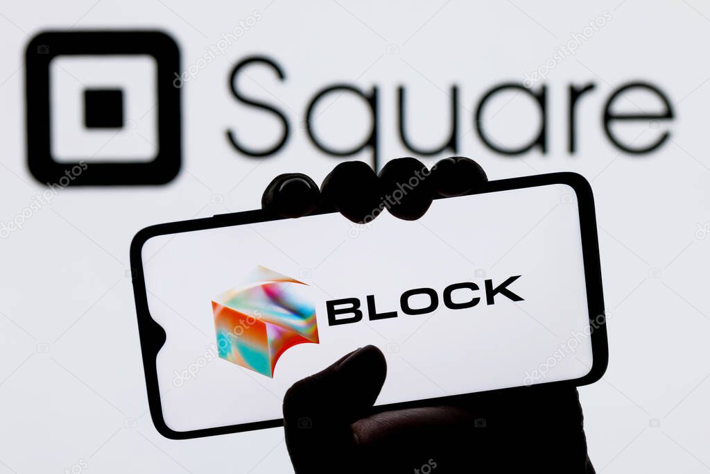Kazan, Russia - Dec 02, 2021: Square, Inc. changes name to Block. Smartphone with Block logo on screen in hand on background of Square logo.