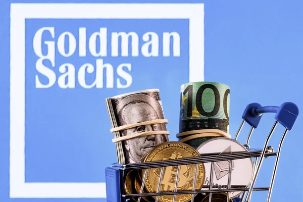 Kazan, Russia - Dec 20, 2021: Crypto and traditional currencies in shopping cart on background of Goldman Sachs bank logo