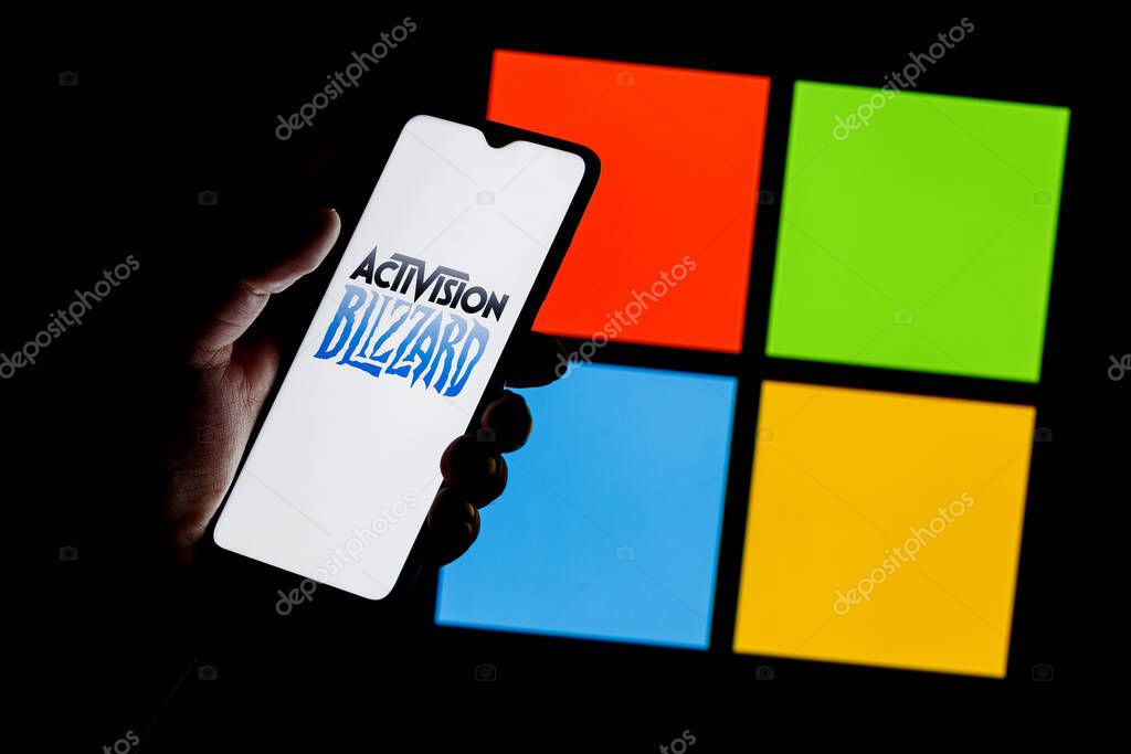 Kazan, Russia - Jan 18, 2022: Activision Blizzard logo on smartphone screen in hand against background of Microsoft logo. Microsoft announced buying of video game publisher Activision Blizzard.