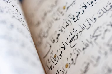 Açık kitabın sayfasında Arapça kaligrafinin kapatılması