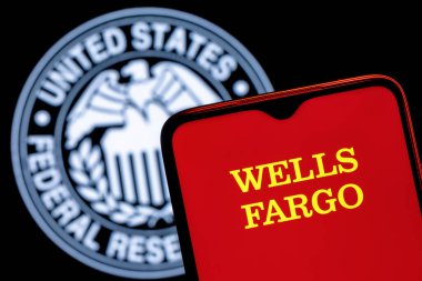Kazan, Rusya - 30 Ocak 2022: Federal Rezerv sembolünün arka planında Wells Fargo banka logosu bulunan akıllı telefon
