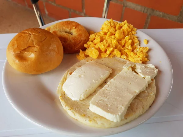 Vista di una colazione a base di paisa, uova strapazzate, arepa con formaggio e pane — Foto Stock