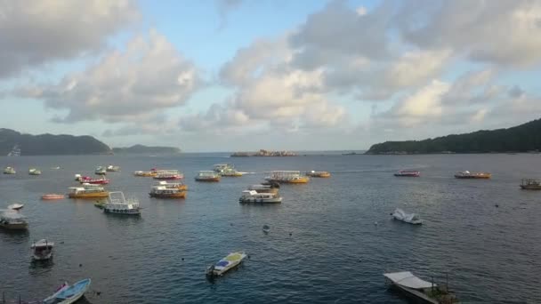 Volando sobre el mar entre varios barcos cerca de las playas de Caleta, Acapulco — Vídeos de Stock