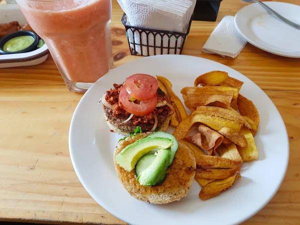 Hambúrguer saudável com abacate e tomate com banana frita — Fotografia de Stock