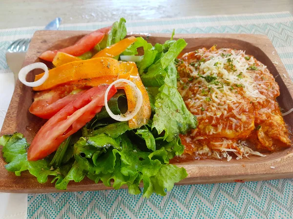 Bolognese-Lasagne mit Salat auf einem Holzteller — Stockfoto