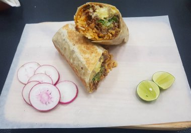 Limon ve turpla birlikte bir biftekli burrito resmi