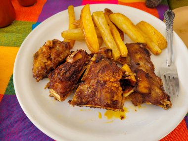 Pirinç, salata ve kızarmış patatesle servis edilen yelken balığı omurgası.