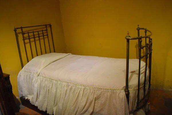 Image of an old bedroom, with white sheets inside a museum, Mexico